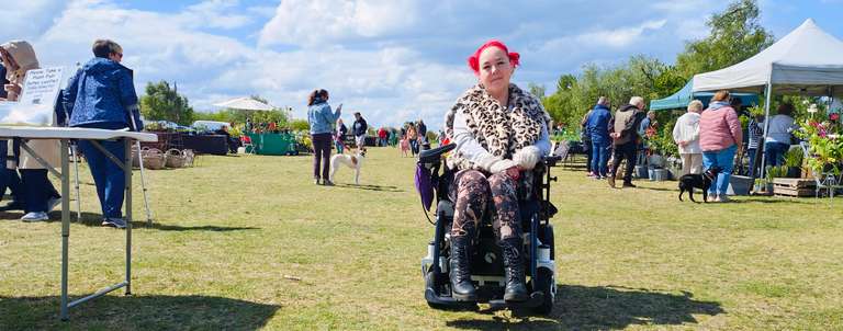 Me at the Chasewater plant fair, surrounded by stalls and people browsing. The wheelchair's handling the grassy terrain pretty well, and I'm looking fabulous in my leopard print coat and floral trousers. Nothing stops a plant lover - not even FND! Wheels and deals at the plant fair.