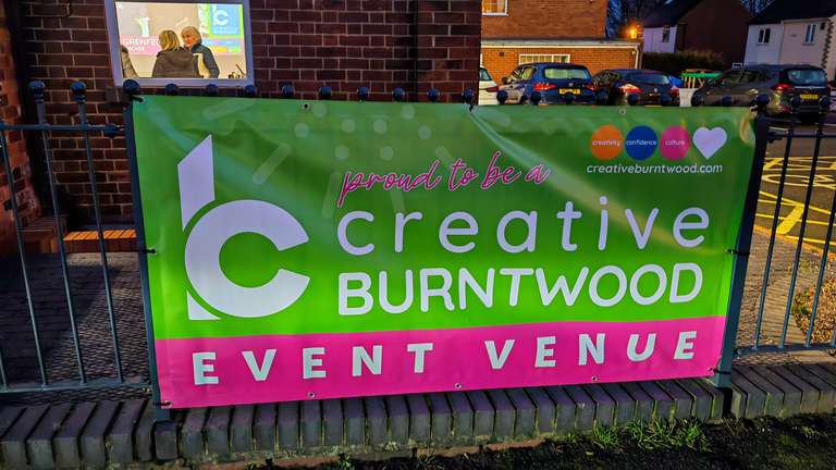 The bright green and pink Creative Burntwood Event Venue banner outside Chase Terrace Community Centre in the evening. 'Proud to be a creative' it says at the top, along with their website creativeburntwood.com. This is where the magic (and my subsequent downfall) happened yesterday. Brilliant organisation, wonderful people, absolutely knackering for someone with FND. Would do it again though. Probably. Ask me when I can see straight.